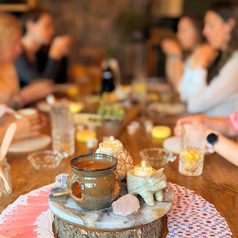 Een cirkel van vrouwen aan tafel in het atelier